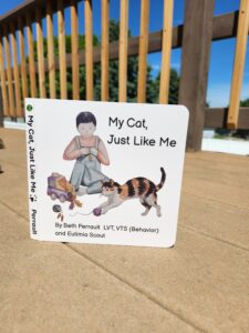 Photo of book cover child playing with toys and cat pouncing